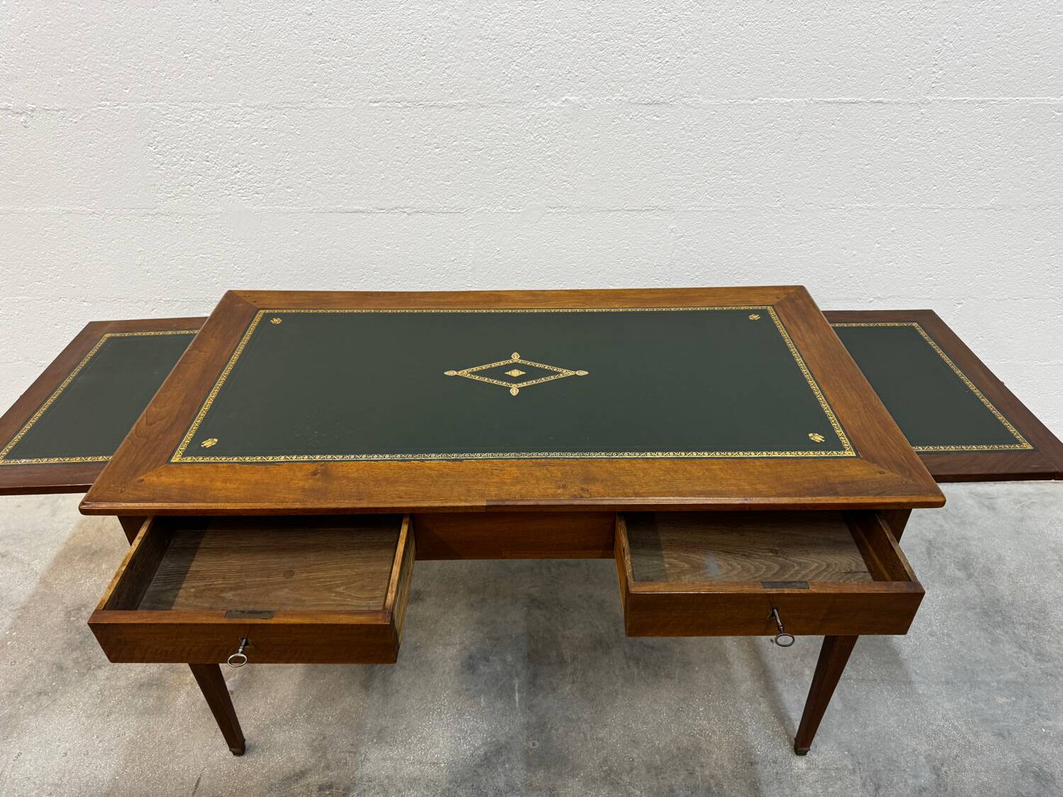 Louis XVI desk with green leather and shelves.
