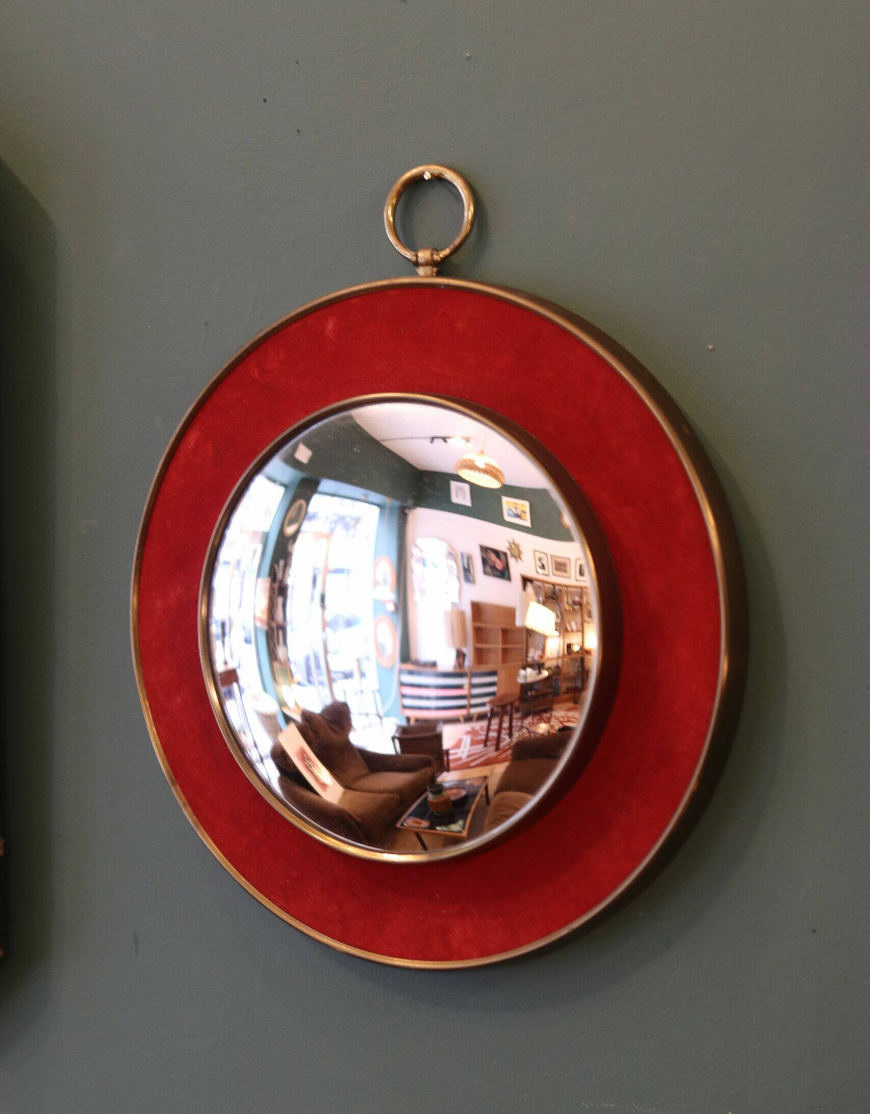 Witch's eye mirror in brass and red velvet