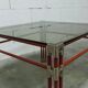 Postmodern Italian design coffee table in smoked glass with red steel structure