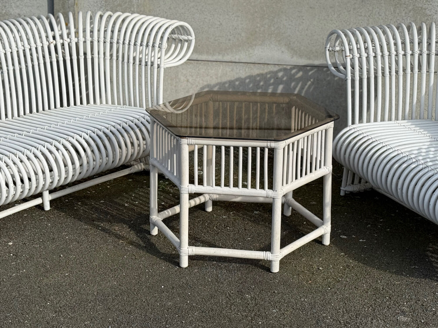 Rattan lounge with two two-seater sofas and a white coffee table.