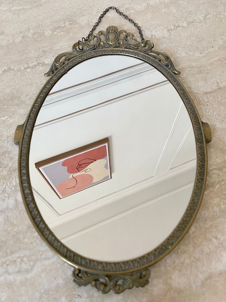 Oval mirror in gilded brass