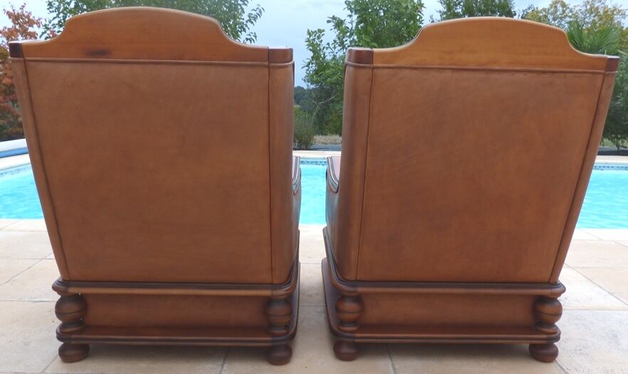 Pair of aged leather armchairs with seat and firm backrest with cherry wood frame