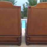 Pair of aged leather armchairs with seat and firm backrest with cherry wood frame