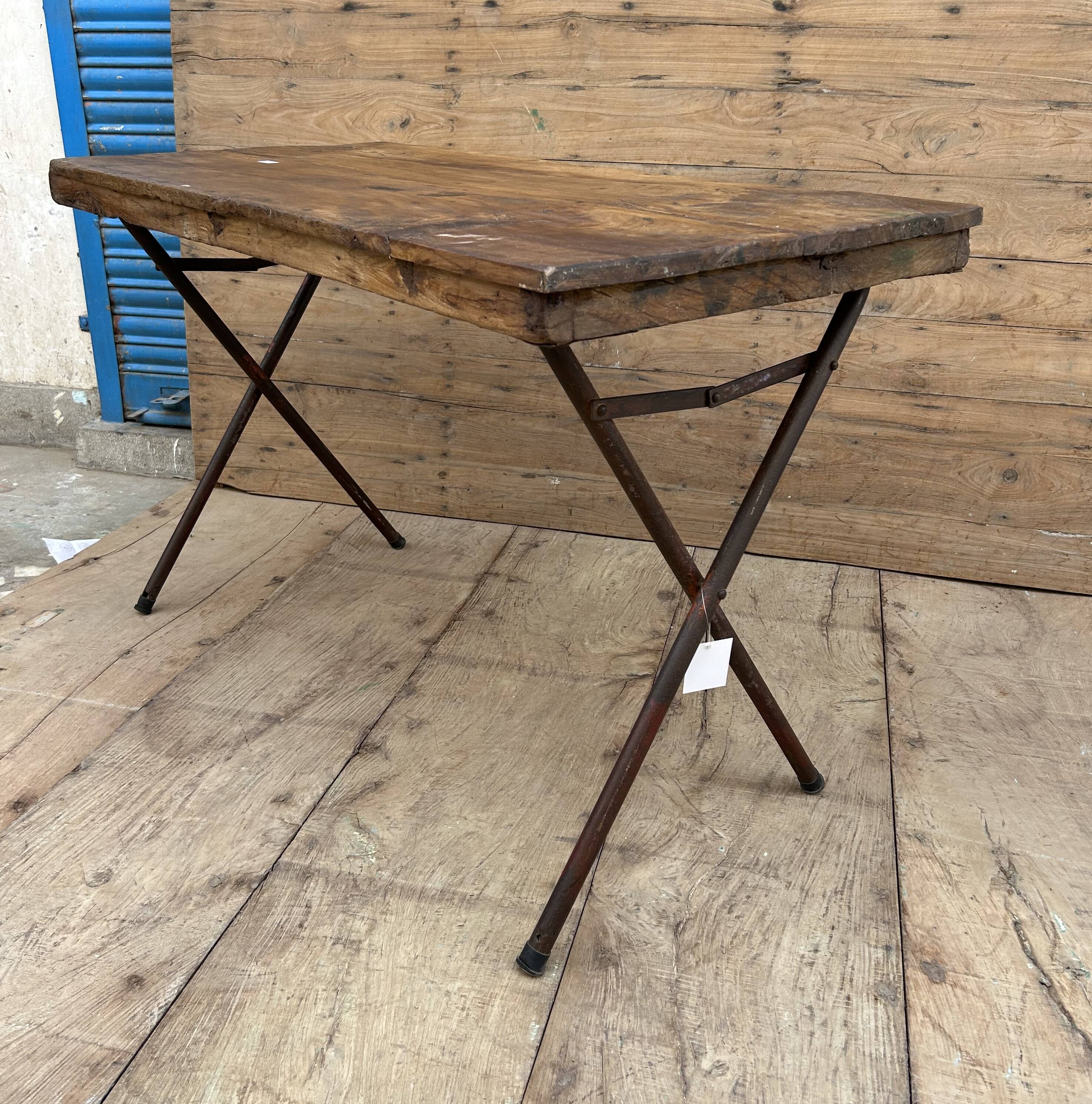 Folding workshop table with a metal frame and solid teak top.