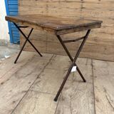 Folding workshop table with a metal frame and solid teak top.