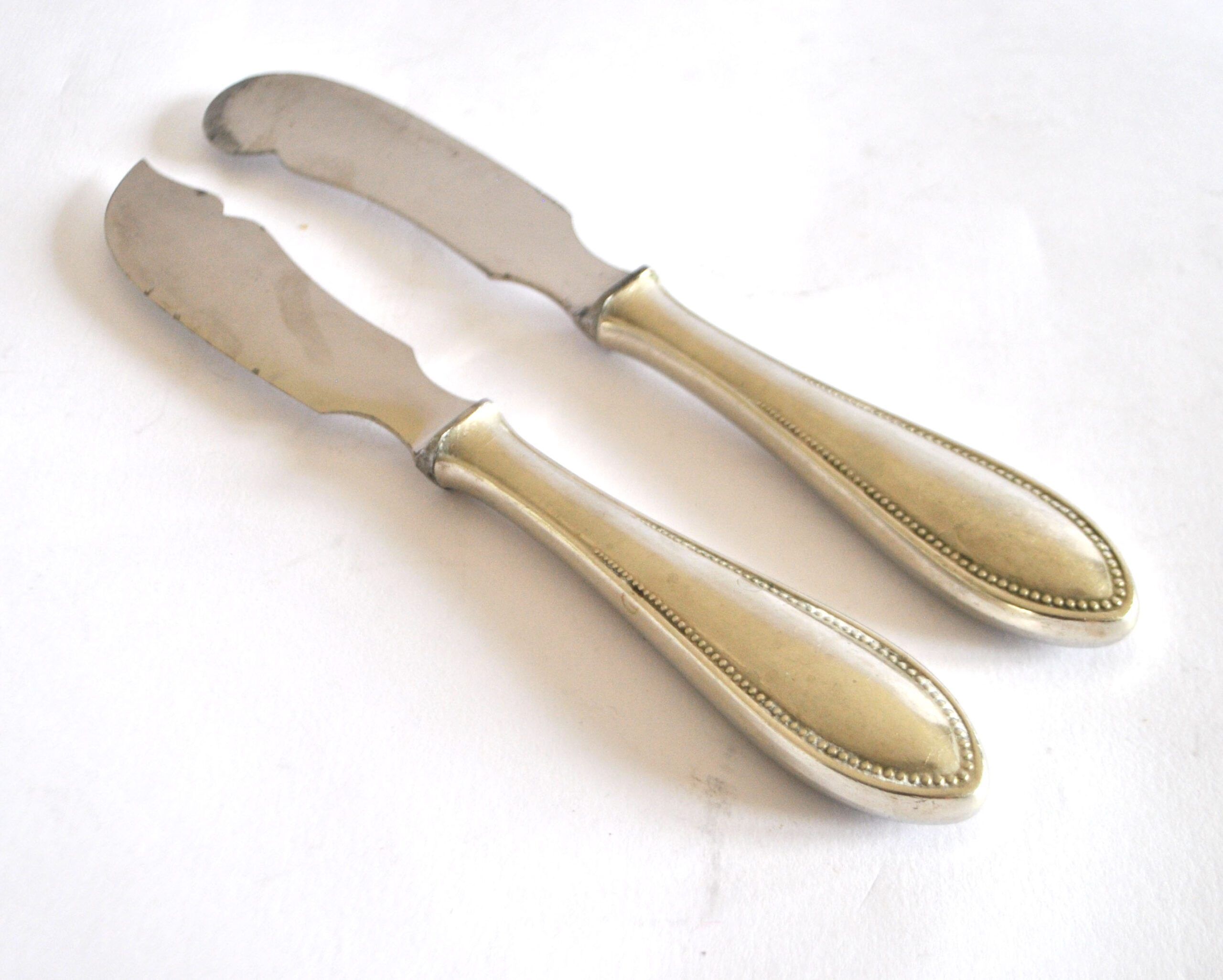Two antique service knives in silver-plated metal, pearl frieze gowe alpacca.