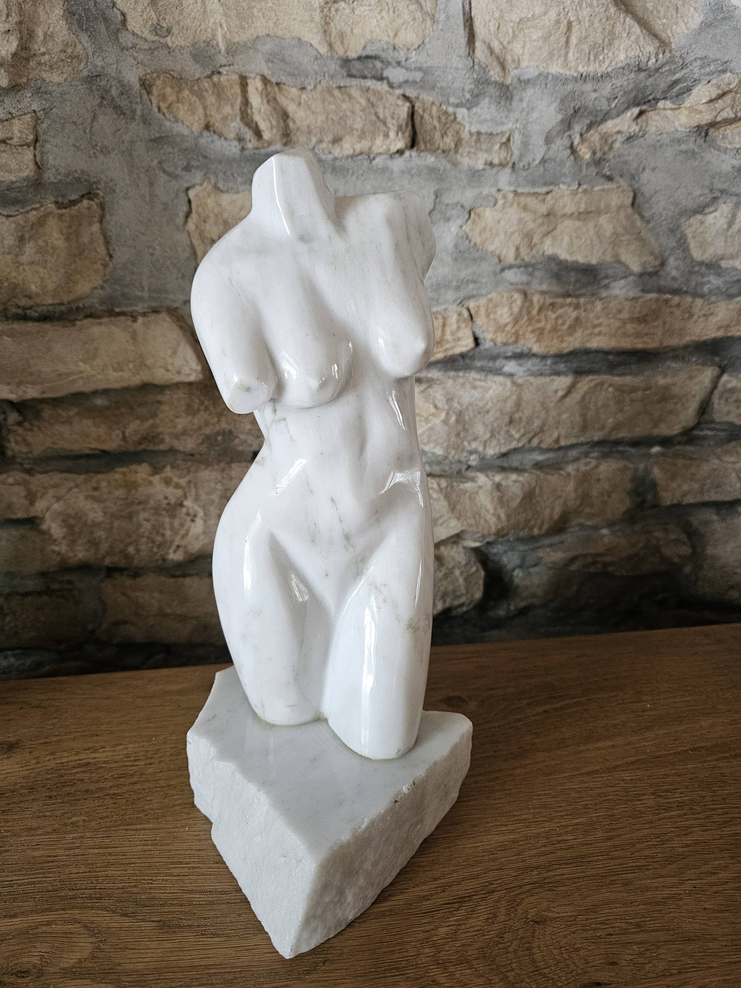 Sculpture of a female torso in white marble.