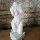 Sculpture of a female torso in white marble.