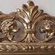 Mirror with a carved wooden frame in an antique style in pure gold.