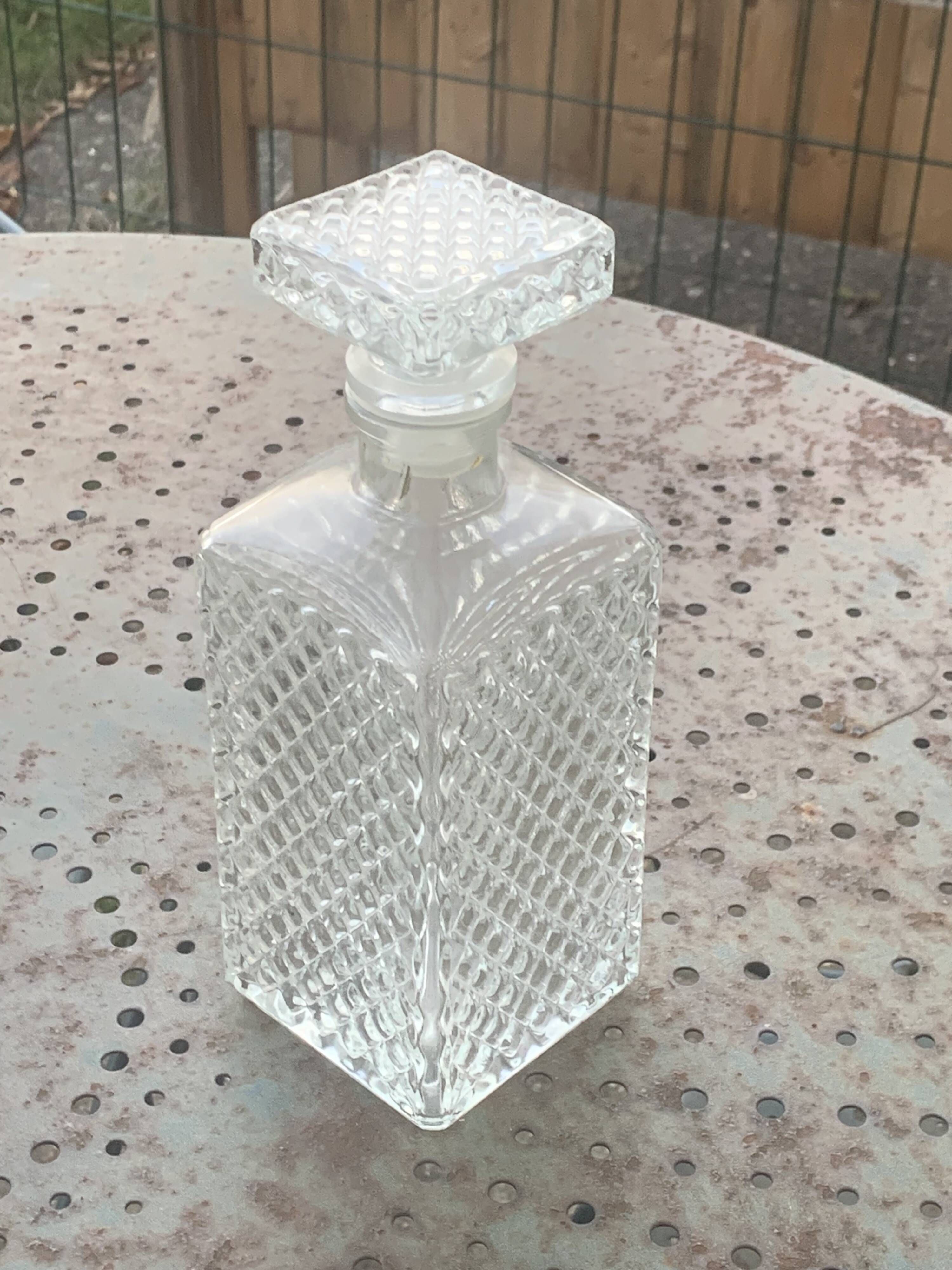 Whiskey carafe and ice bucket in transparent glass and silver-colored metal handle