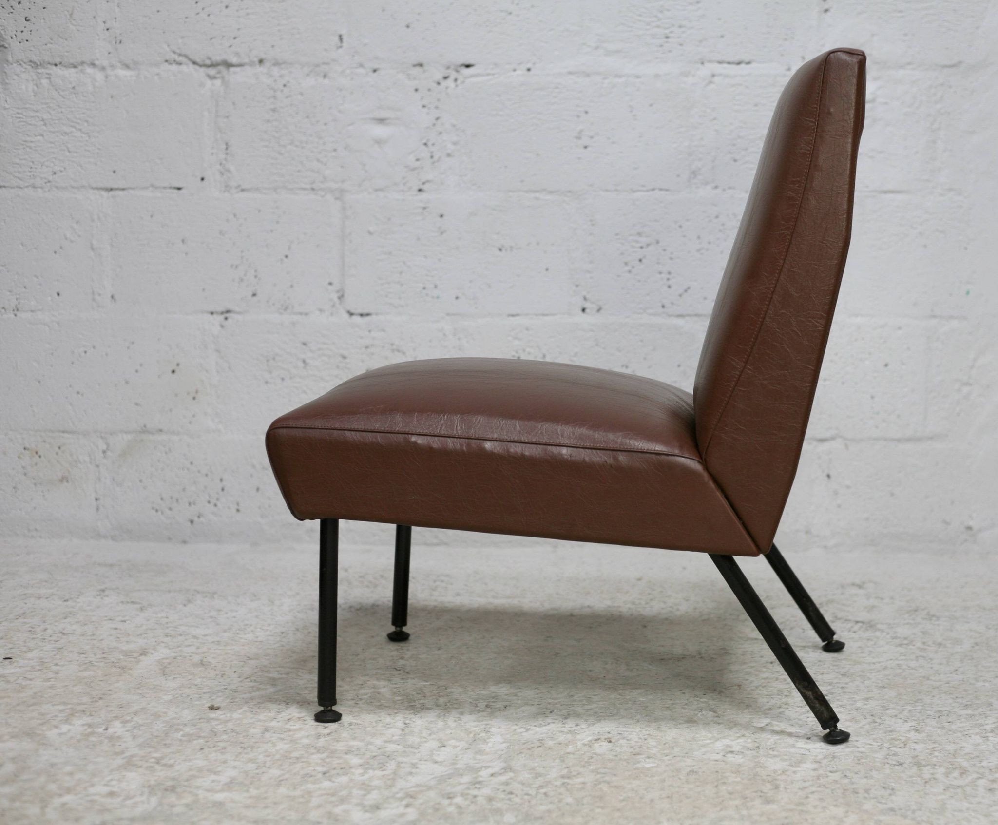 Chauffeuse, circa 1950. Simili-cuir brun.