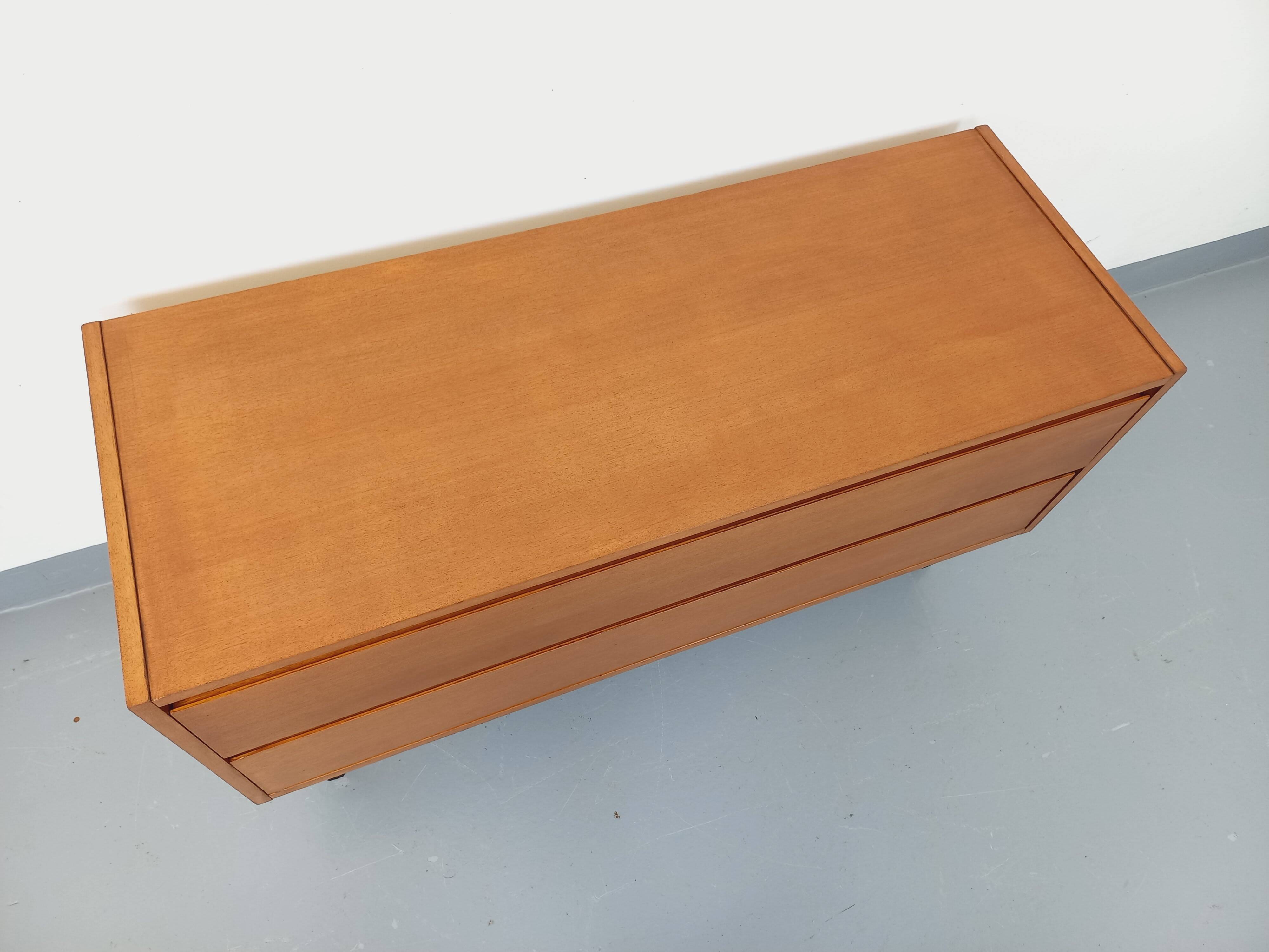 Small vintage Scandinavian sideboard in modernist style made of light oak wood.