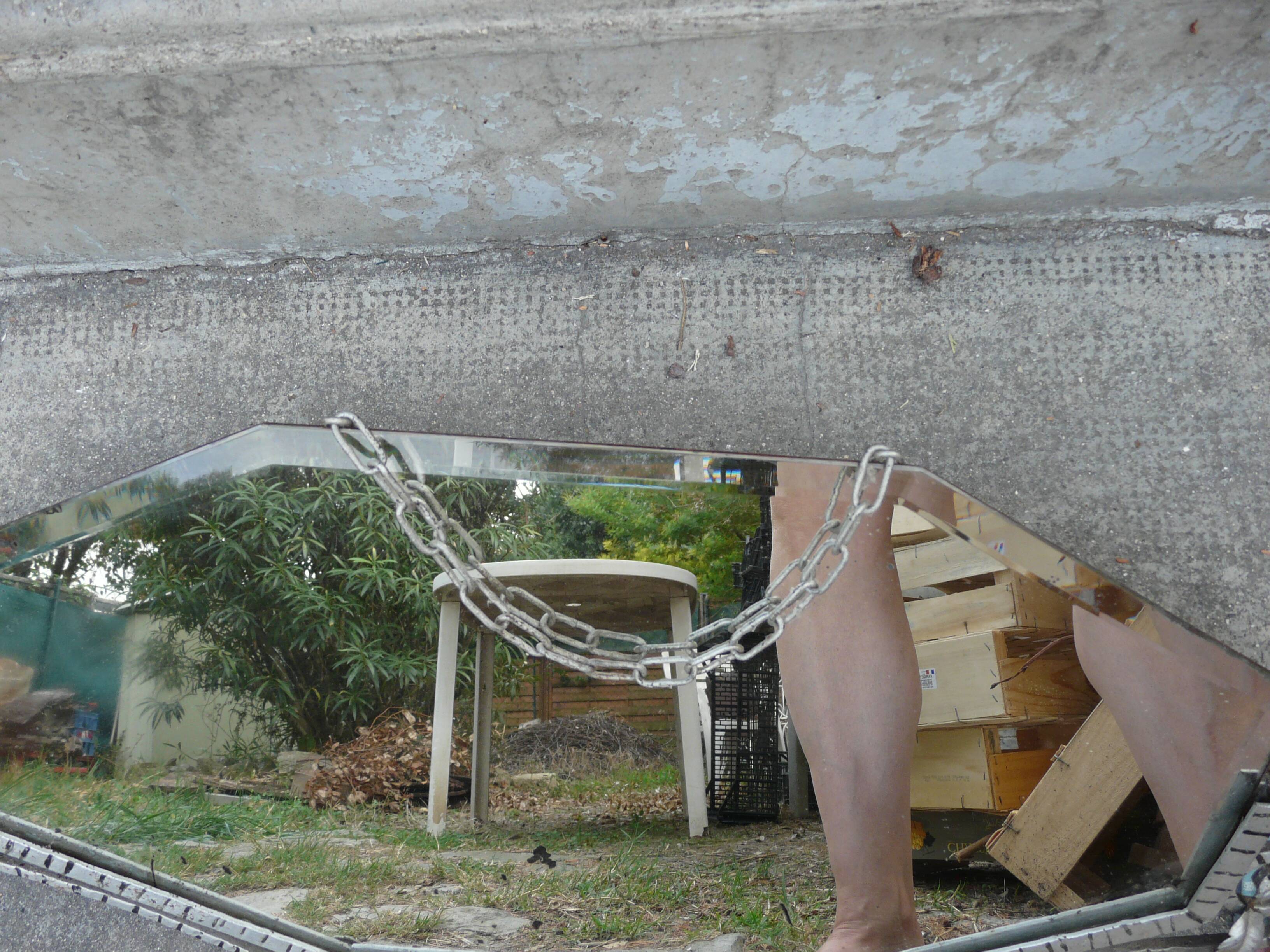 Beveled mirror with art-deco wrought iron frame and floral decor with hanging chain