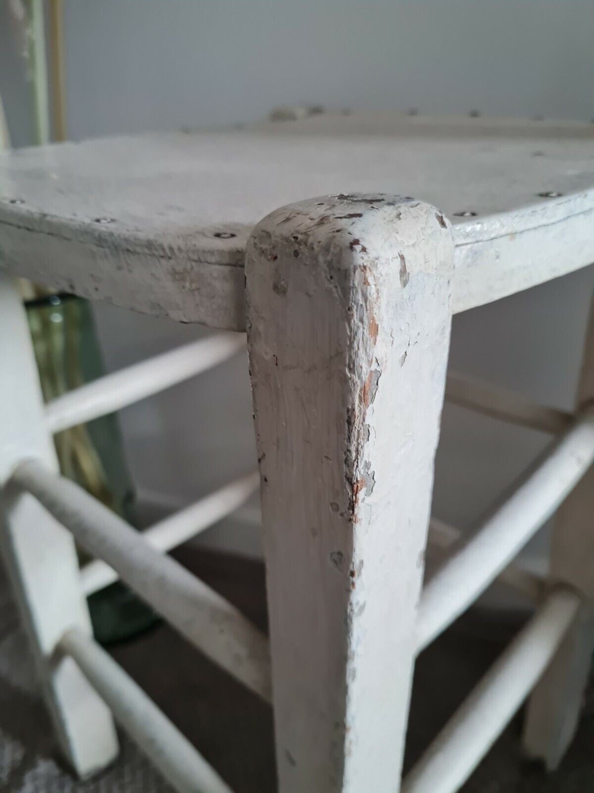Vintage wooden stool with white peeling paint