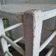 Vintage wooden stool with white peeling paint