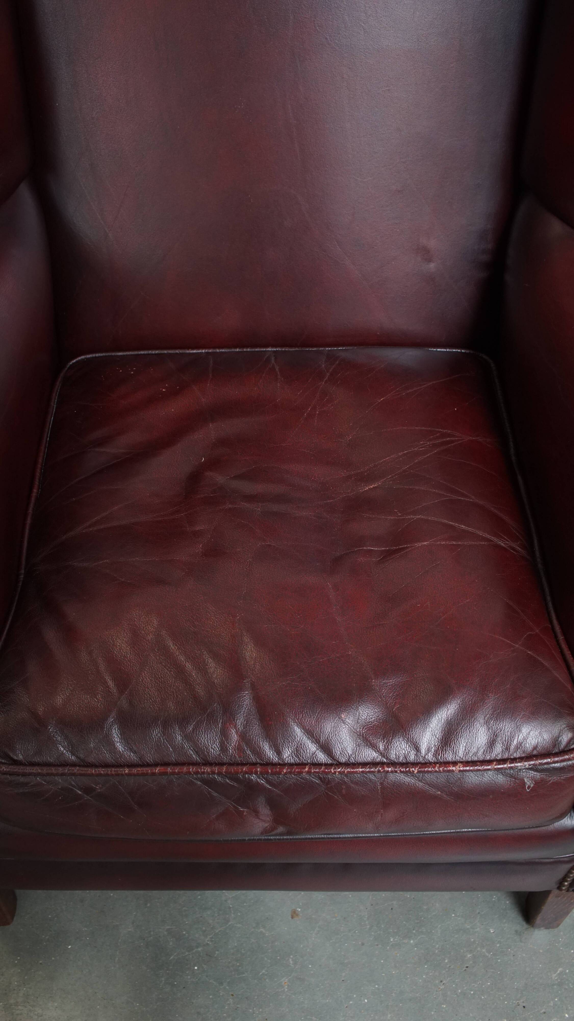 Ensemble de 2 fauteuils à oreilles en cuir de vachette + pouf de style anglais