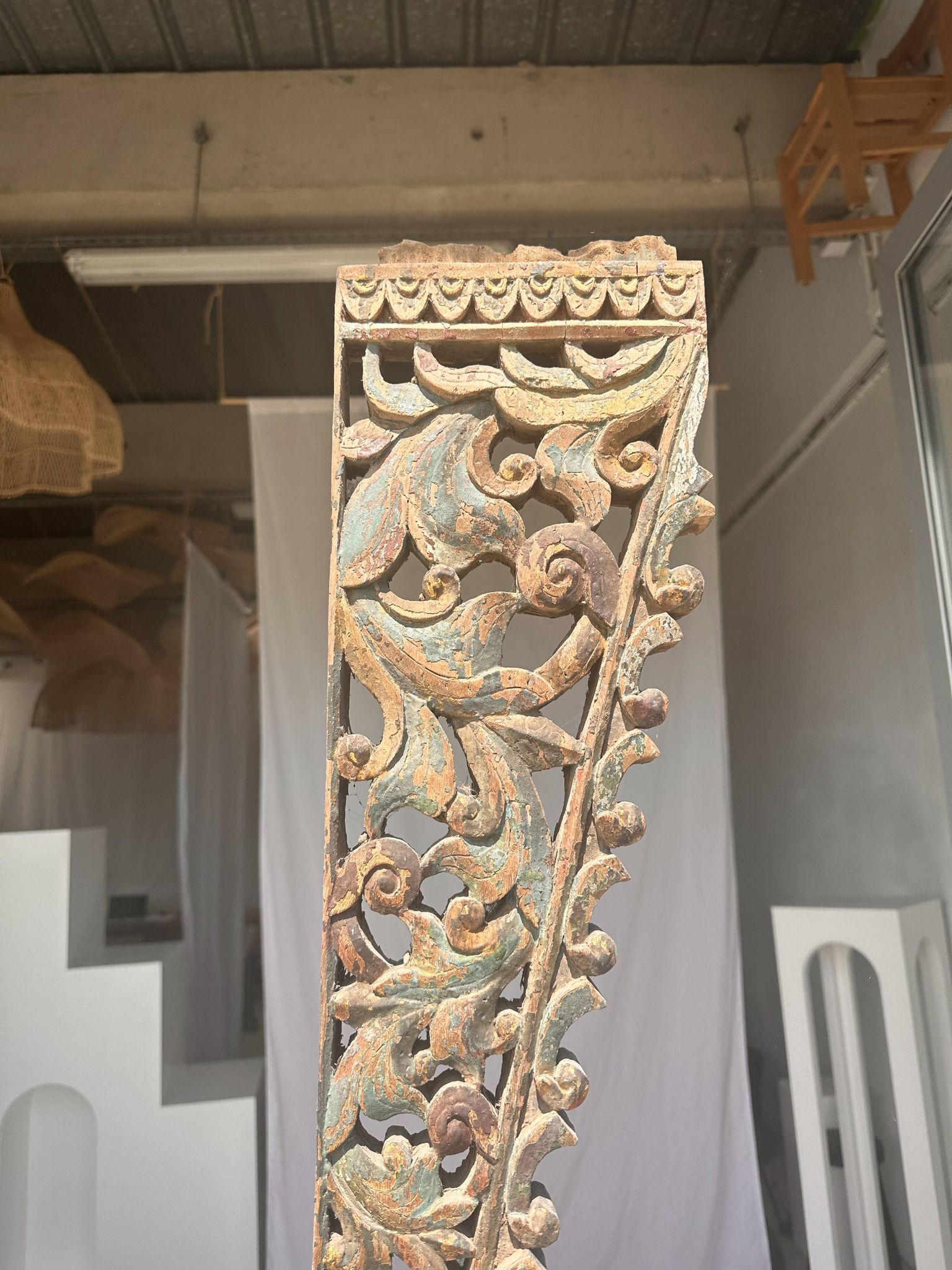Indonesian construction element in carved wood with intertwined plant motifs mounted on a base (fri
