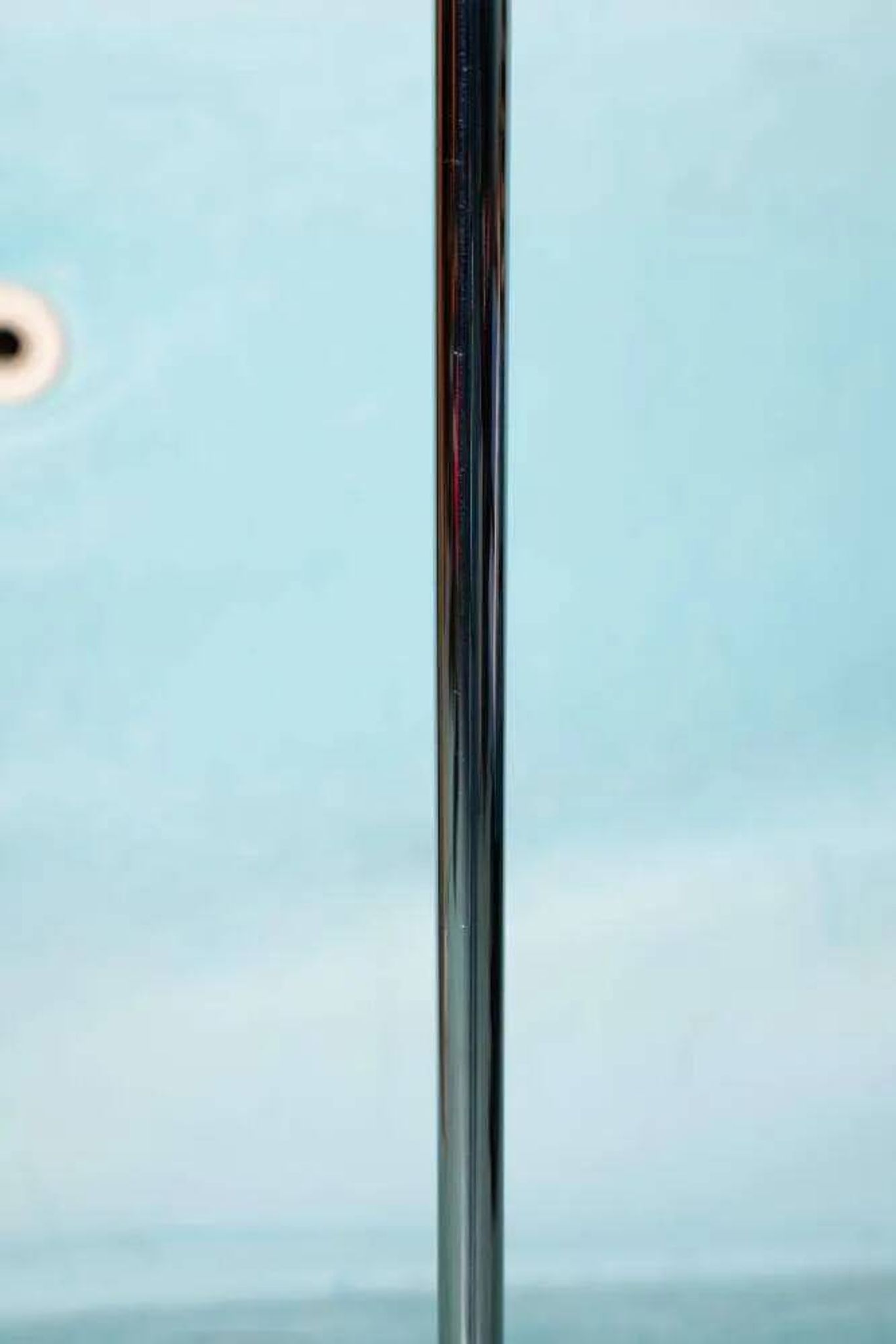 Vintage floor lamp in milky glass and chrome, minimalist uplight lighting.