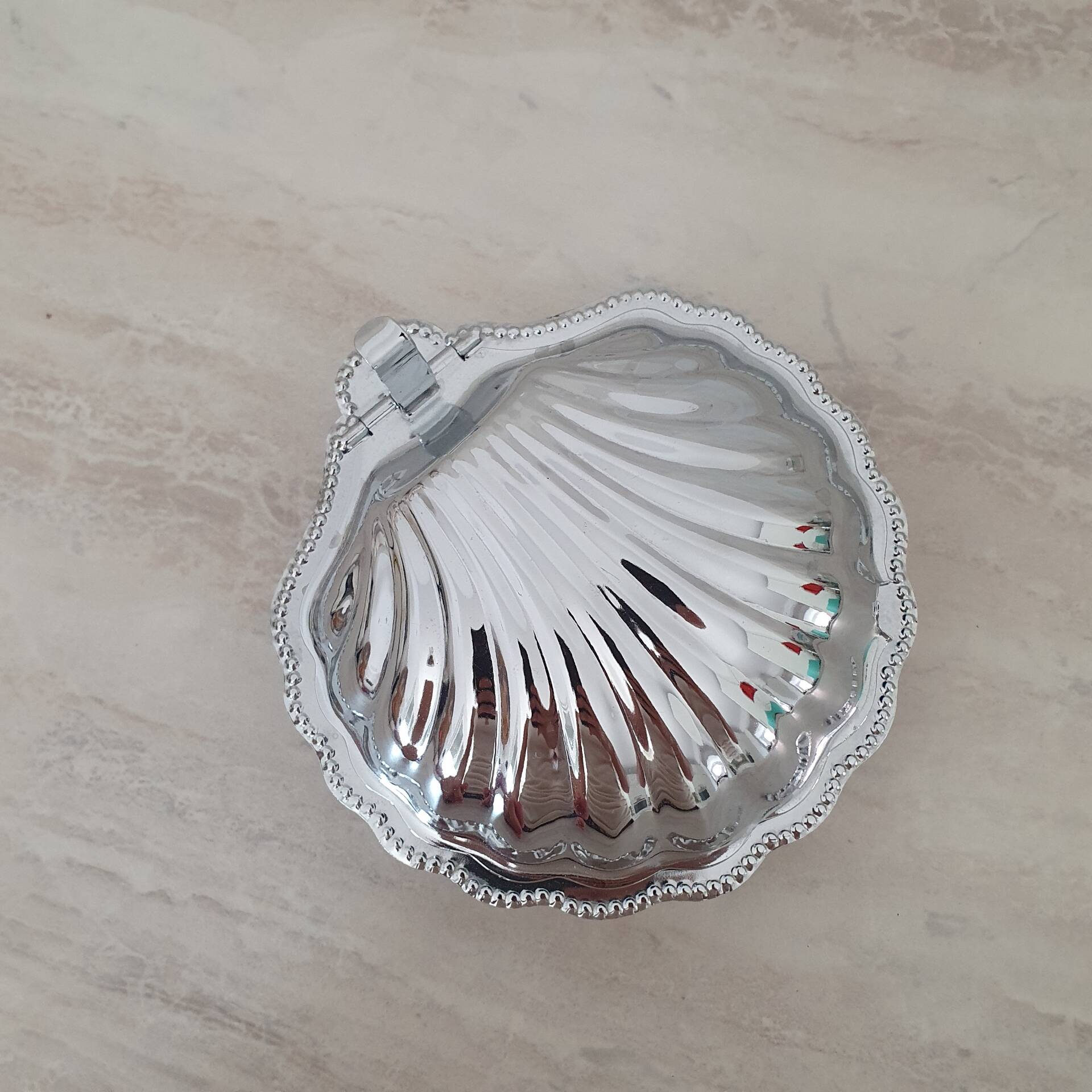 Shell-shaped butter dish in stainless steel and white glass bowl.