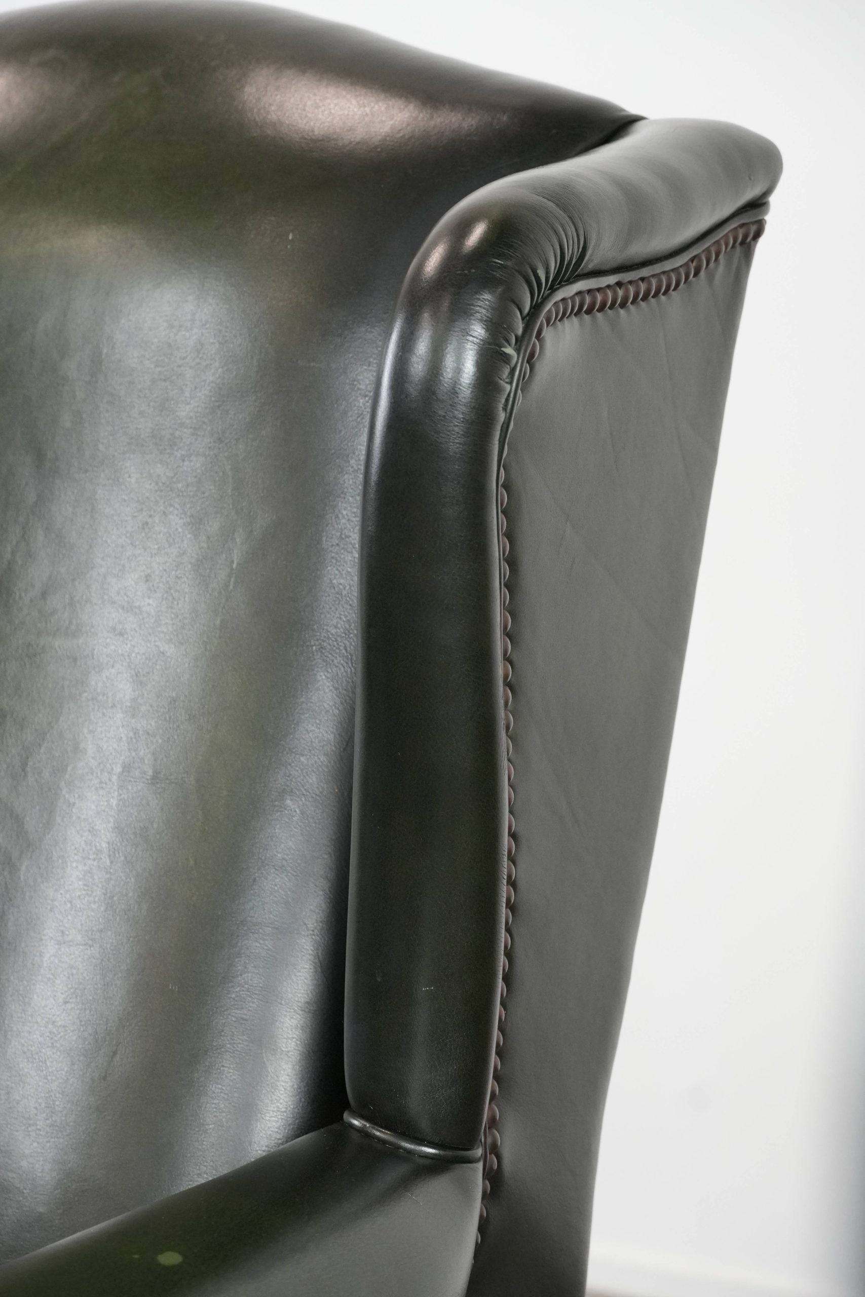 Smooth classic cowhide Chesterfield armchair in a stylish dark green color