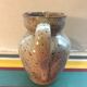 Old gray pitcher with black drawings and vintage stamped handle