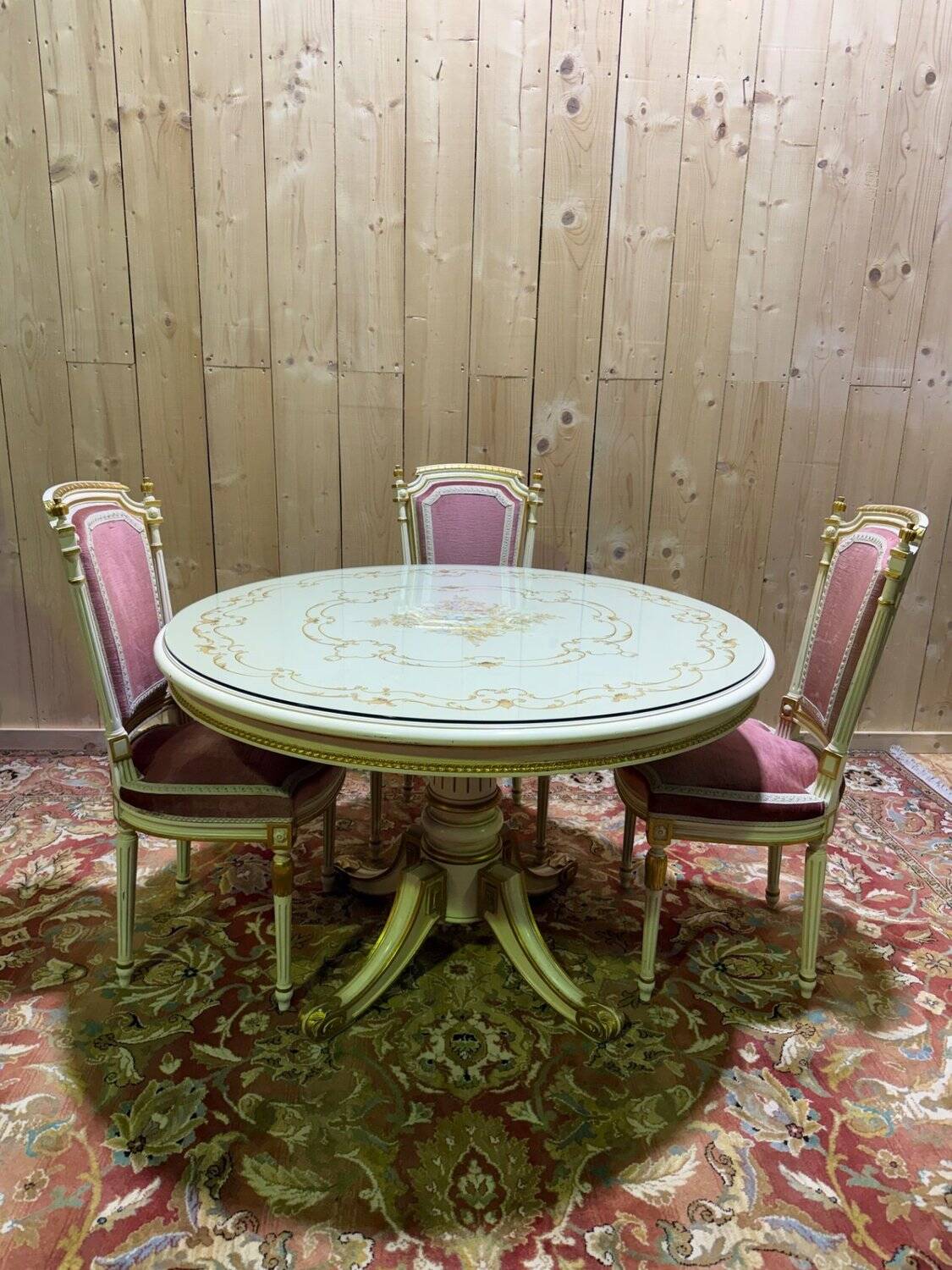 Louis XVI dining room table set with painted wood, gold accents, and pink velvet.