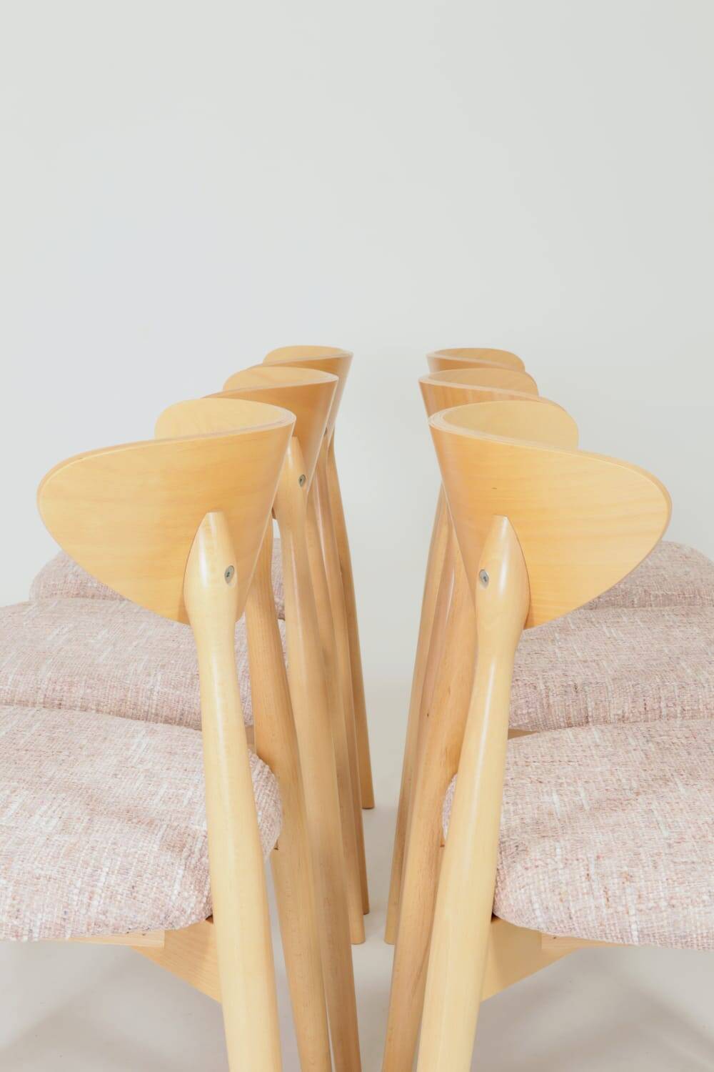 Set of 6 pale pink dining chairs in natural wood.