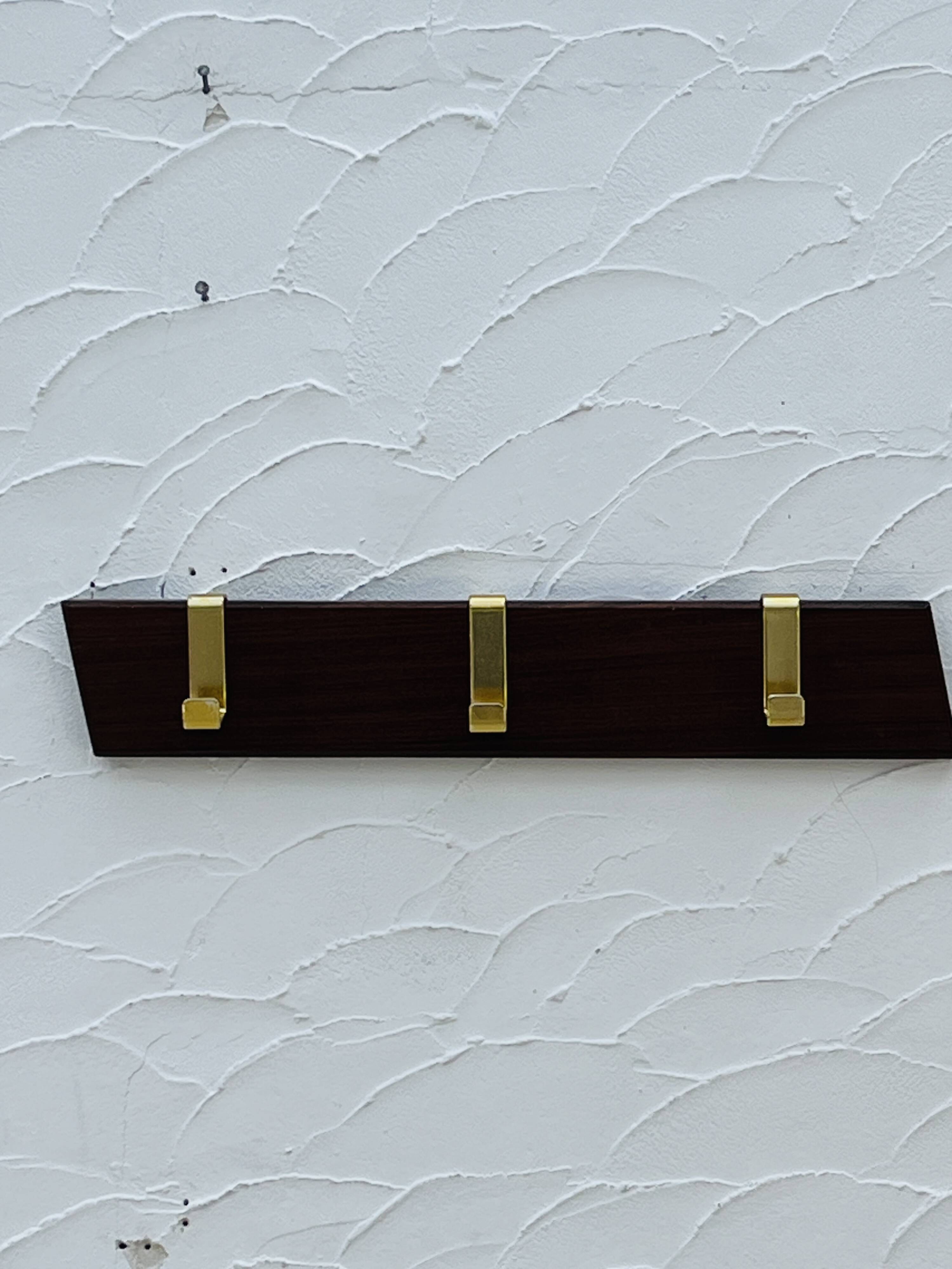 Vintage wooden and brass coat rack with 3 hooks from the 1960s.