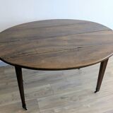 Antique wooden folding table with a patina and brass wheels.