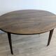 Antique wooden folding table with a patina and brass wheels.