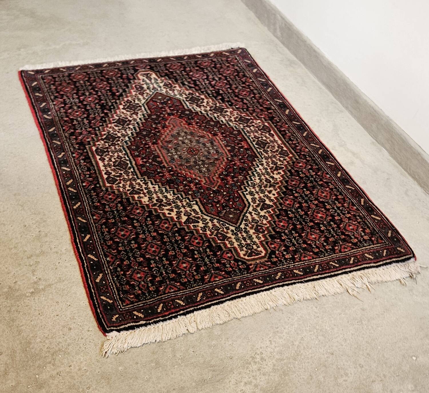 Ancient Persian carpet, wool, red tones, hand-knotted.