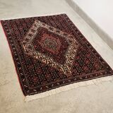 Ancient Persian carpet, wool, red tones, hand-knotted.