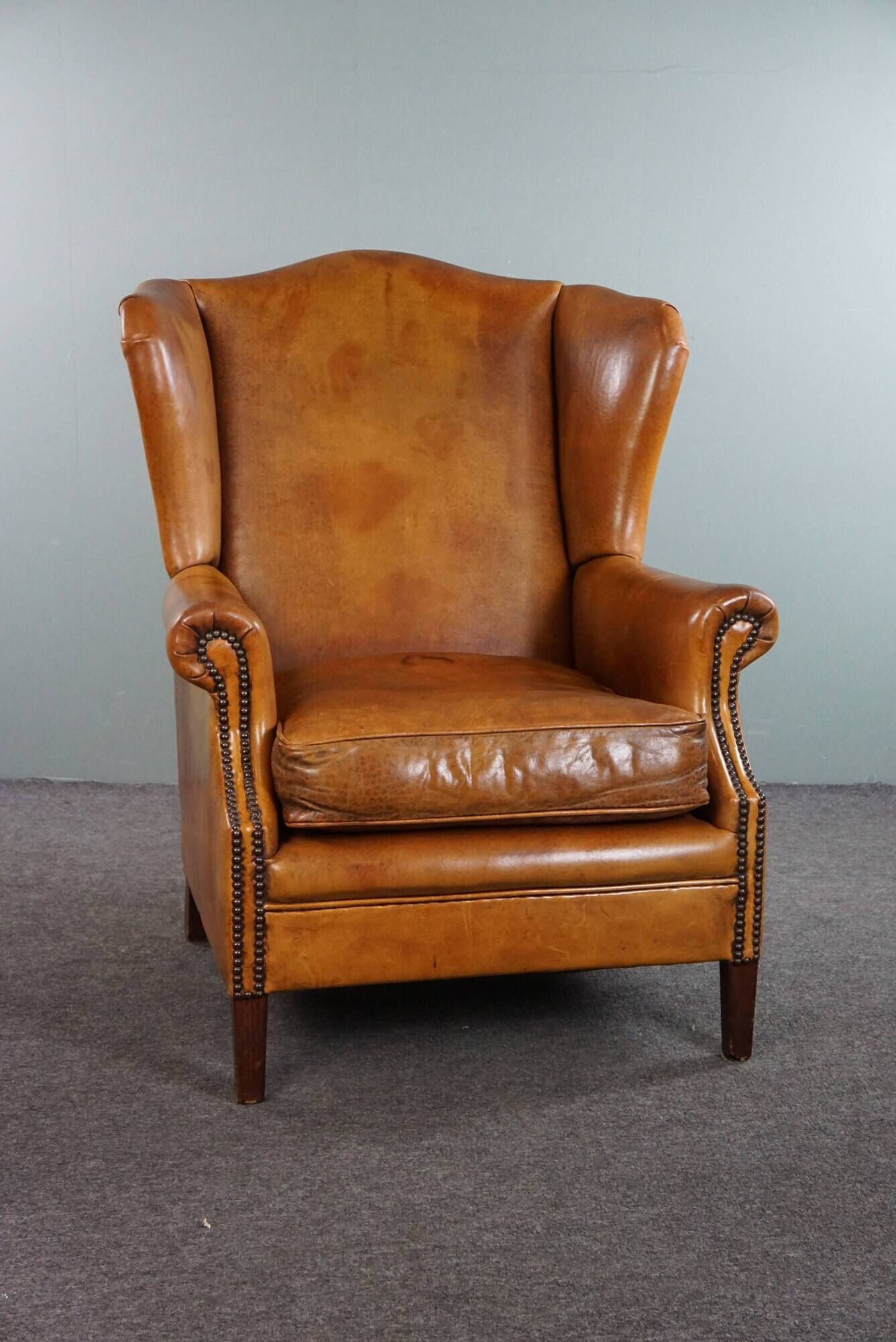 Wingback chair made of sheepskin leather in a light honey color