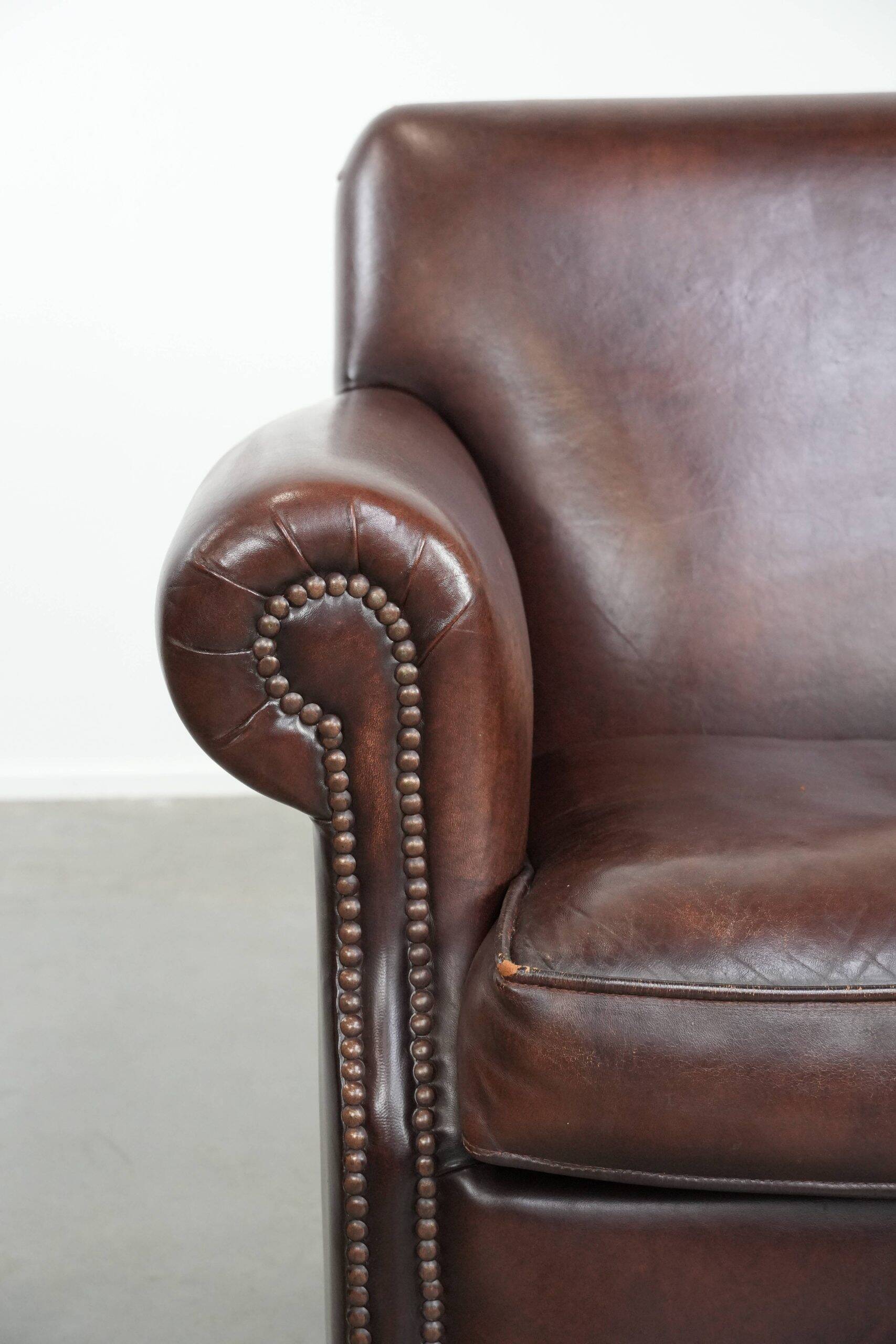 Sheepskin armchair with a classic finish and decorative studs.