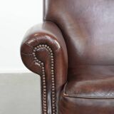 Sheepskin armchair with a classic finish and decorative studs.