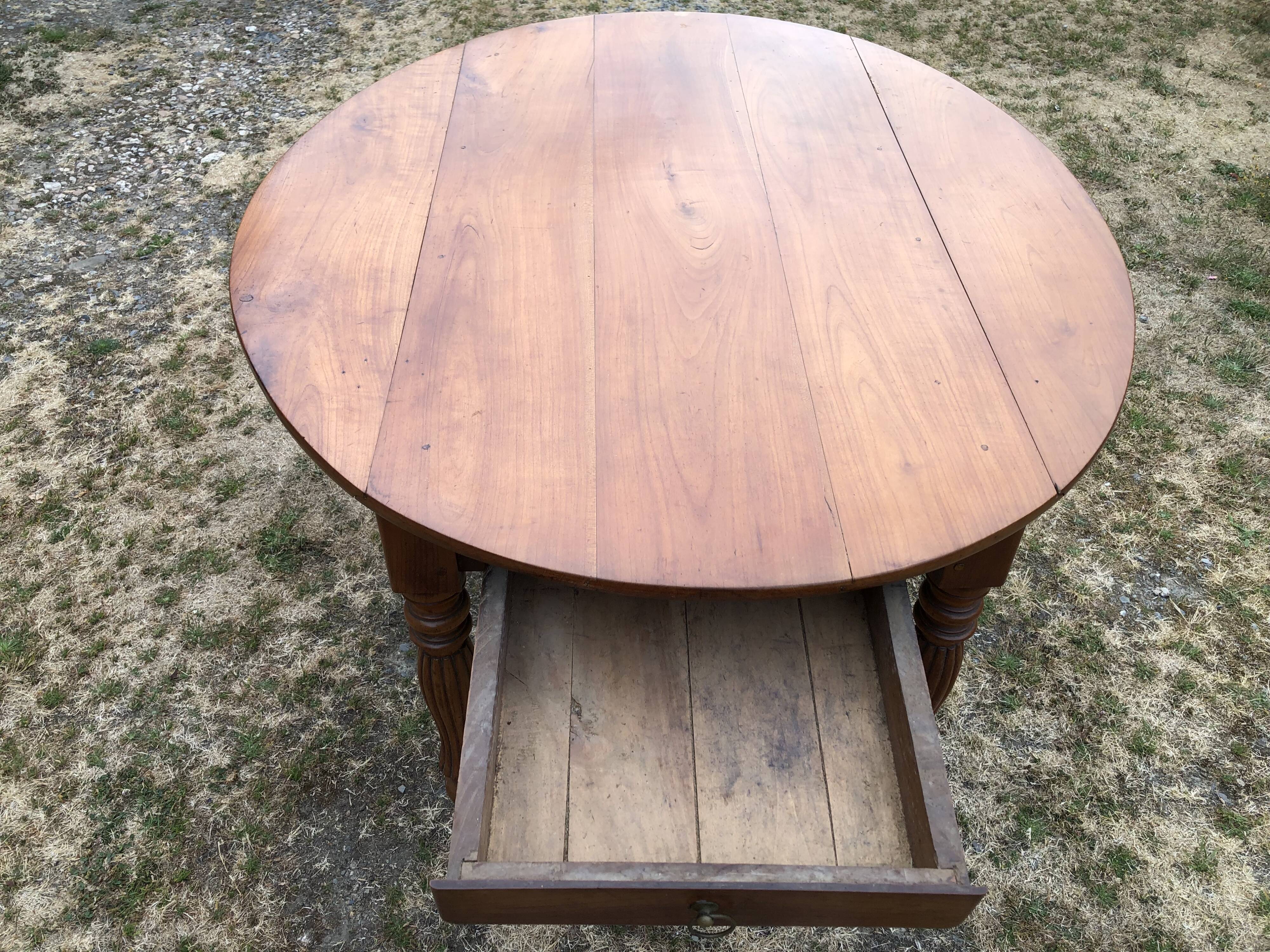 Louis Philippe oval drop-leaf table in solid cherry wood with 2 drawers.