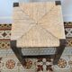 Vintage rustic stool in wood with a straw seat.