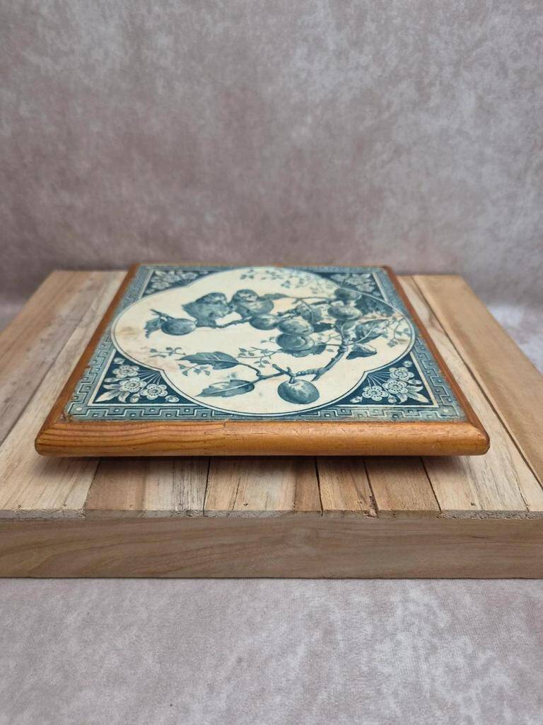 Antique trivet in Gien tile with blue bird decoration – wooden border