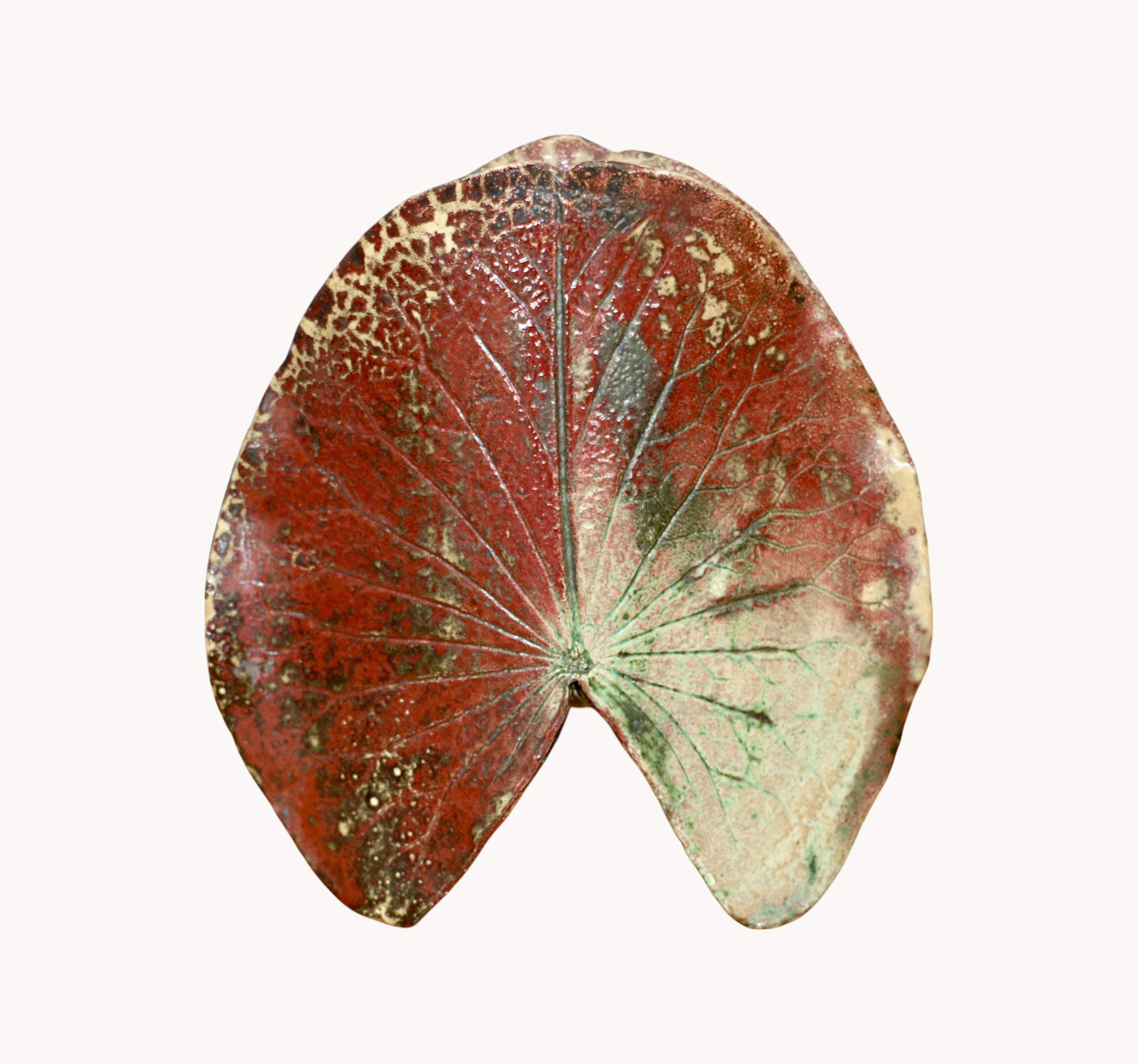 A ceramic lamp in the shape of a leaf.