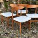 A set of GPlan chairs in teak with a white woolly fabric