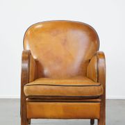 Unique, luxurious sheepskin armchair combined with wood and finished with decorative nails