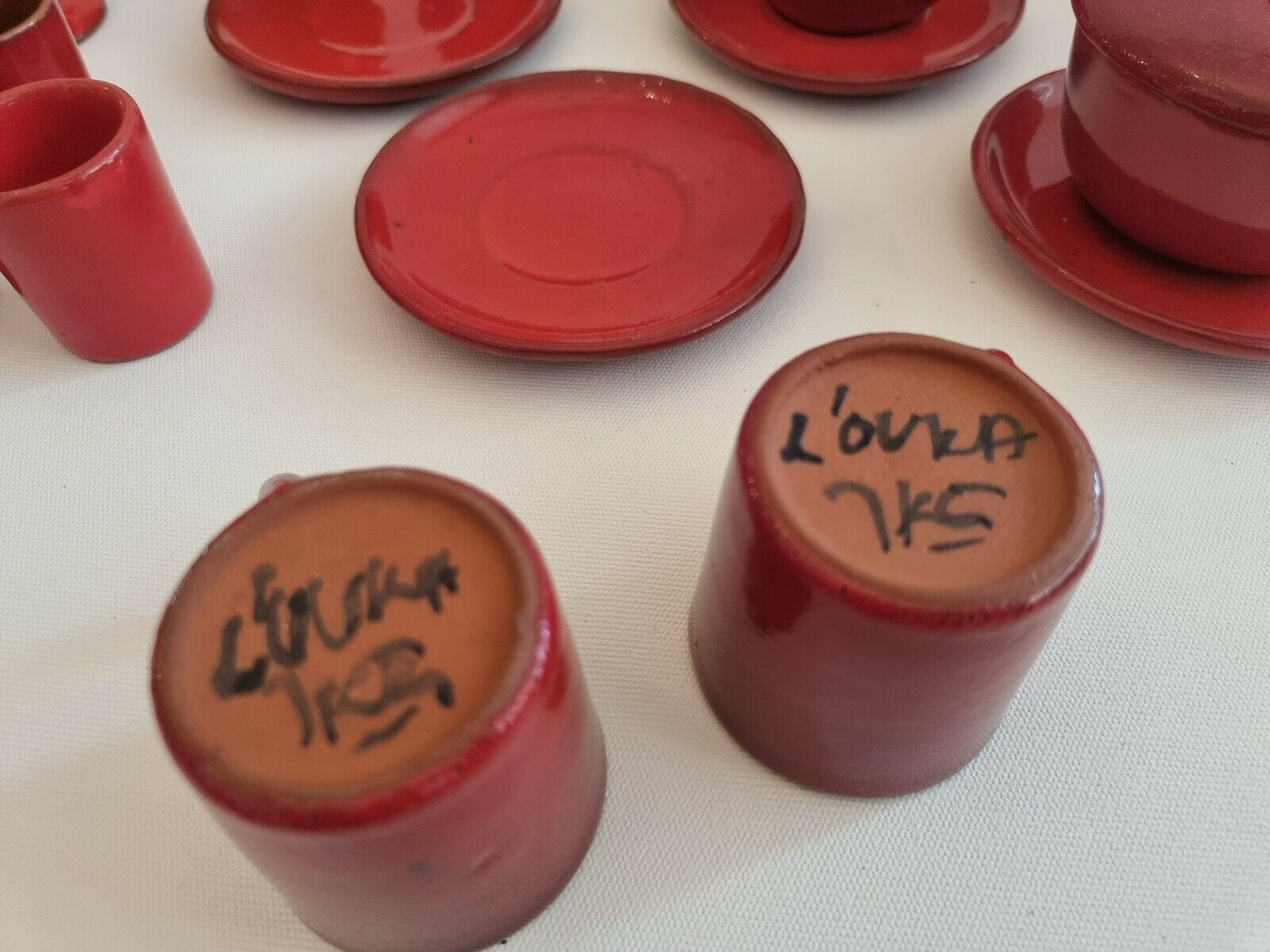 Red enamelled terracotta: cups, saucers, glasses