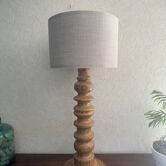 Lampe totem en bois tourné avec un abat-jour en lin dans un style scandinave vintage.