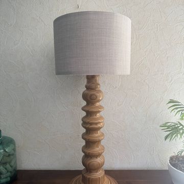Lampe totem en bois tourné avec un abat-jour en lin dans un style scandinave vintage.