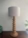 Wooden turned totem lamp with a linen shade in a vintage Scandinavian style.