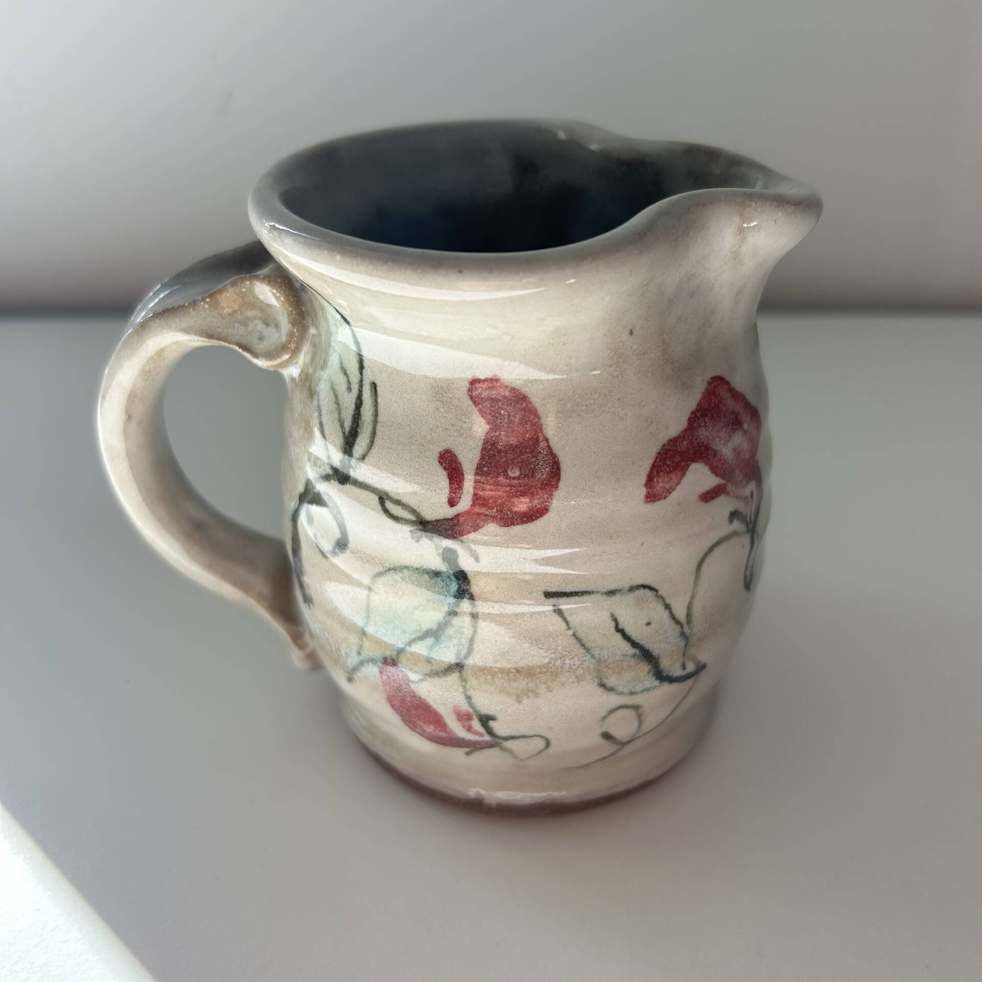 Floral decorated pitcher signed