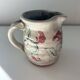 Floral decorated pitcher signed