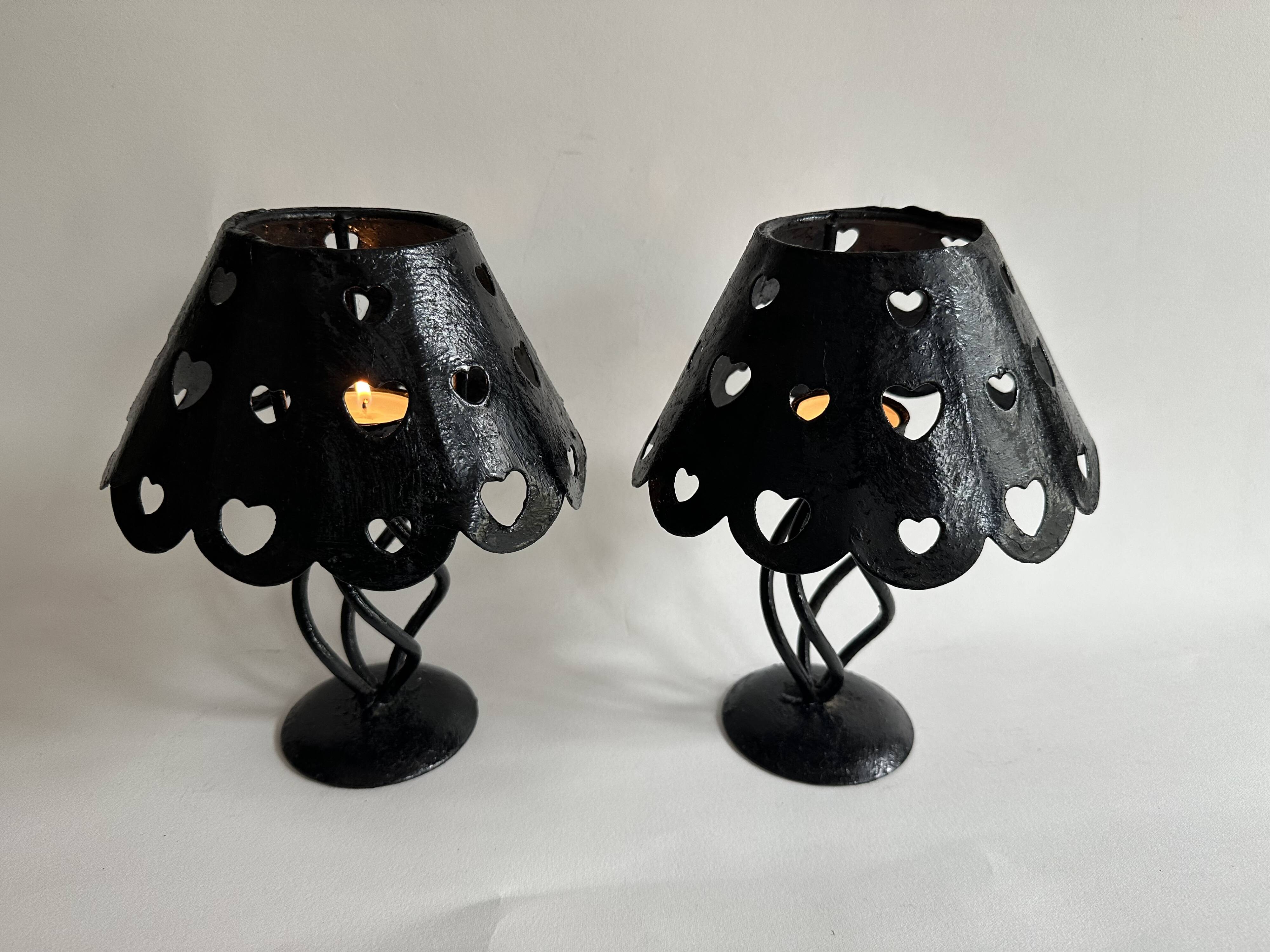 Pair of black wrought iron lanterns with heart patterns, romantic style.
