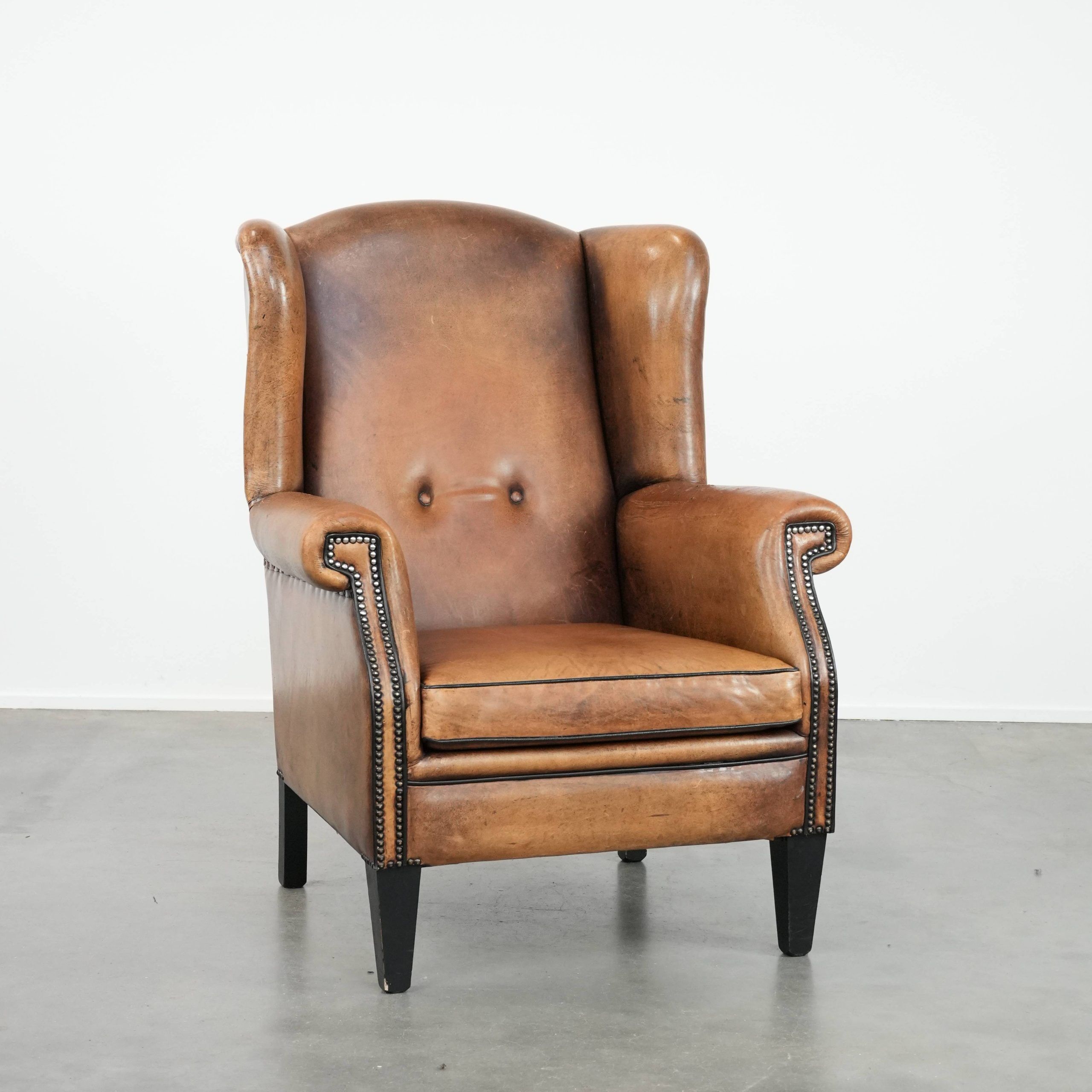 Large and comfortable sheepskin leather wingback chair with black piping