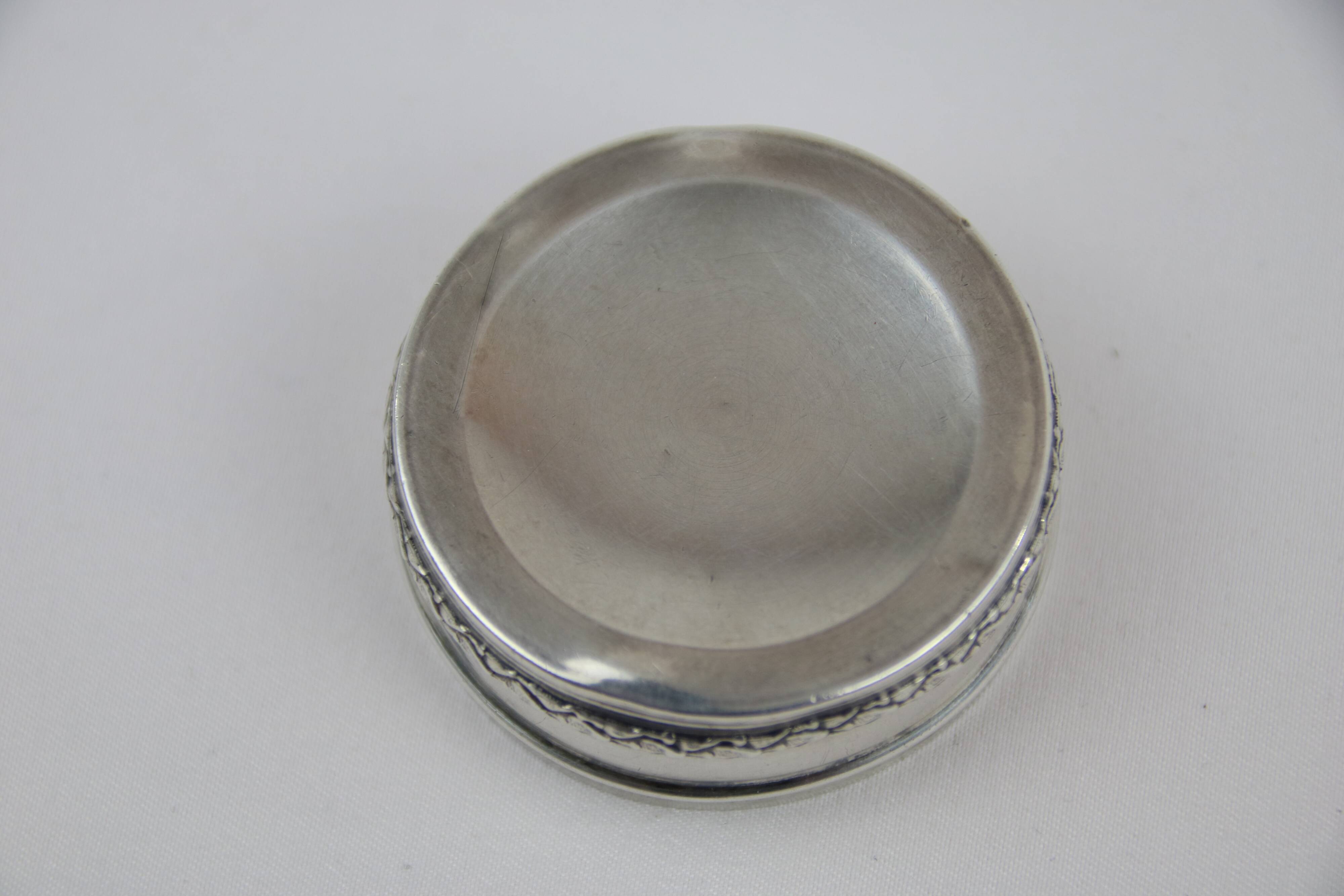 Small round box with silver pills